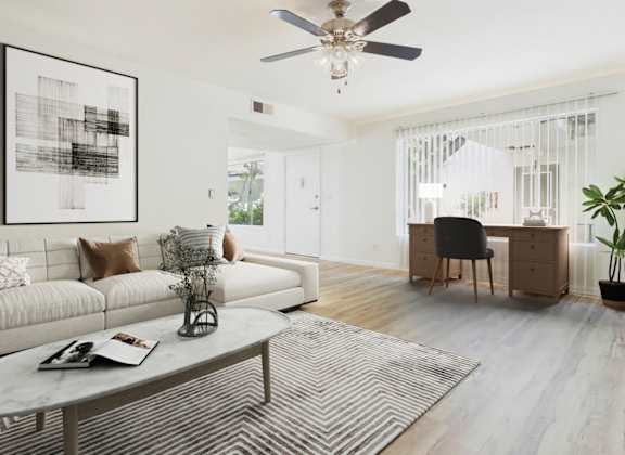 A living room with a white couch, a coffee table, and a ceiling fan.
