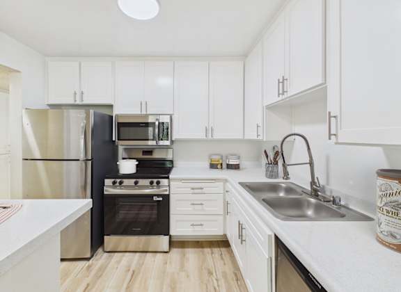 A kitchen with white cabinets and a black stove.