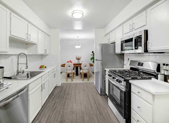 a kitchen with stainless steel appliances and white cabinets