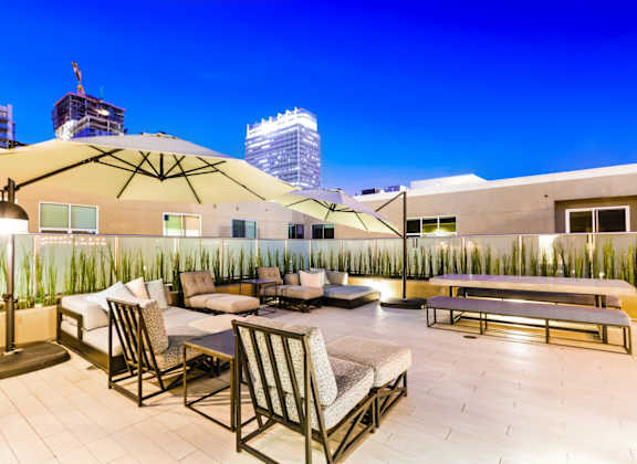 A rooftop patio with a table and chairs.