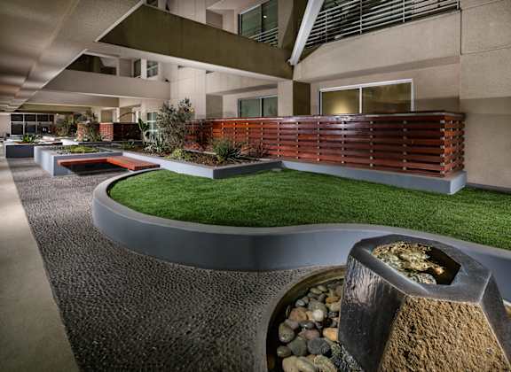 A modern house with a curved roof and a small garden in front.