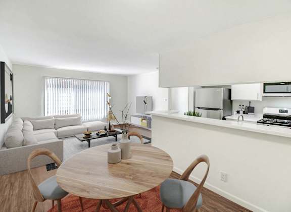 a living room with a table and a couch and a kitchen