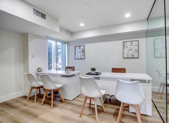 a white office with a white desk and chairs