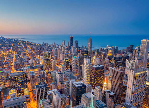 A city skyline at dusk with buildings illuminated at 73 East Lake, Chicago, IL