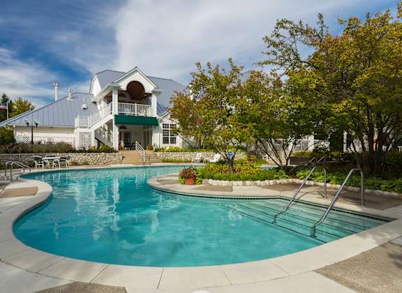 a swimming pool with a house in the background at Village Club of Farmington Hills, Farmington Hills, 48331