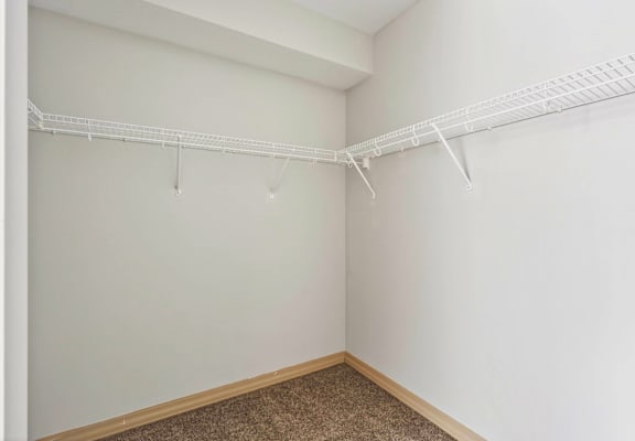 Empty room with a white wall and a white shelf.