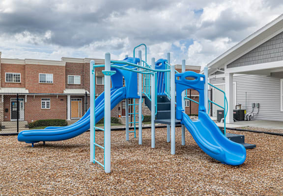 A blue and white playground slide in a residential area.