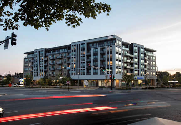 an apartment building at dusk at the intersection of a city street