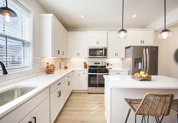 A modern kitchen with white cabinets and a large island.