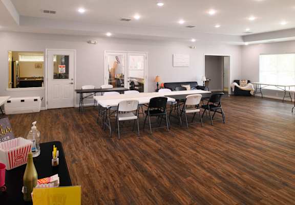a large room with tables and chairs and a living room with a couch