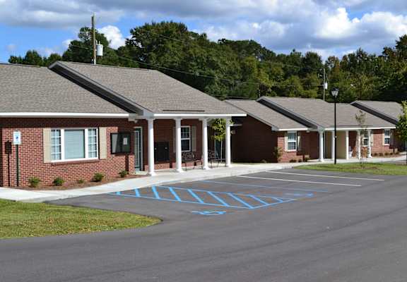 A parking lot in front of a building with a blue painted crosswalk.