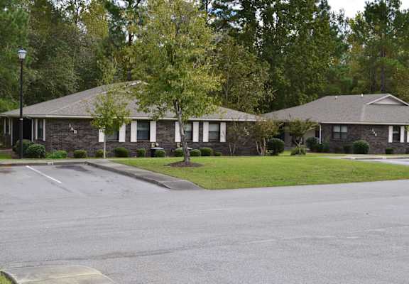 A street view of a residential area with houses and trees.