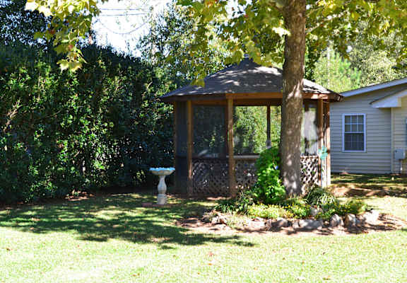 A gazebo is in the middle of a grassy area.