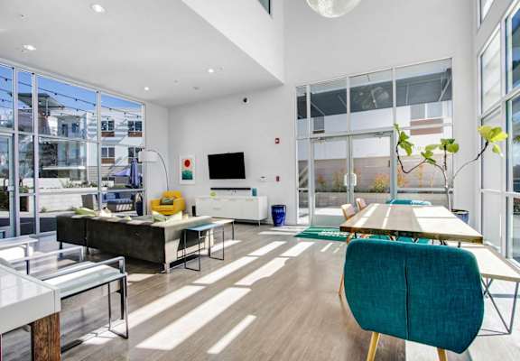 a living room with large windows and a table and chairs