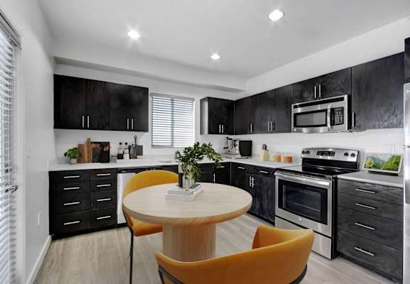 a kitchen with black cabinets and white appliances