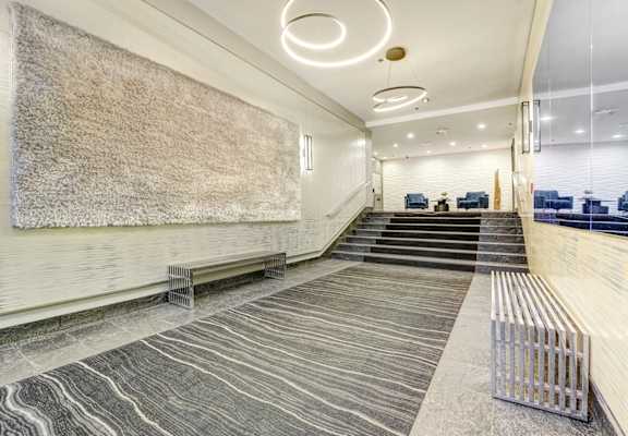 A long hallway with a bench and a staircase.