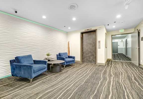 A room with blue chairs and a wooden floor.