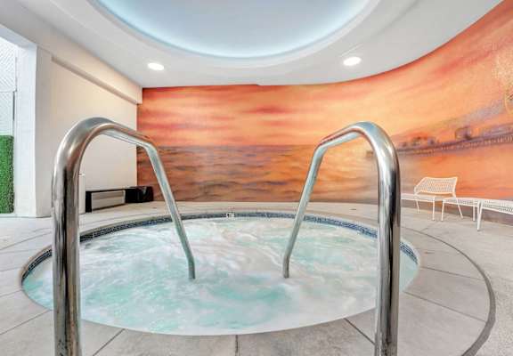 A hot tub in a room with a large mural on the wall.