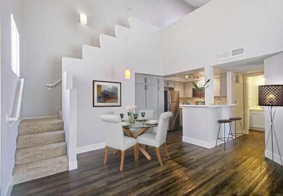 A dining room with a white table and chairs.