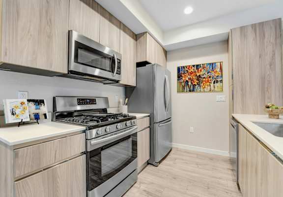 A modern kitchen with a stainless steel refrigerator, microwave, and oven.at The Blvd Lofts, Encino, 91436