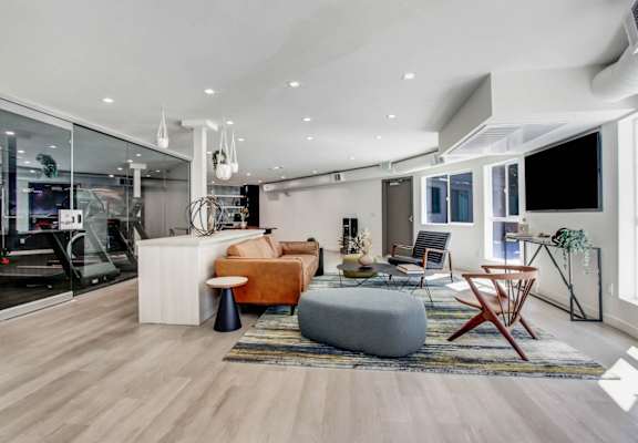 a spacious living room with white walls and hardwood flooring