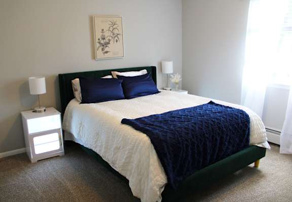 a bedroom with a carpeted floor and white walls at Highview Manor Apartments, NY, 14450