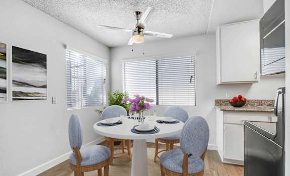 a dining room with a table and chairs and a ceiling fan