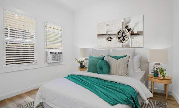 A bedroom with a large bed and a painting above it.