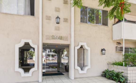 The image shows a building with a beige facade and a sign that reads "1860".
