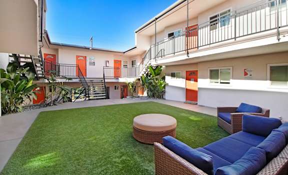 a yard with a couch and a table in front of some apartments
