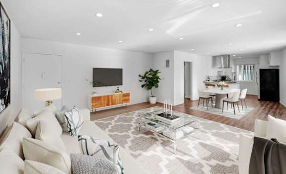 a living room with a white couch and a glass table