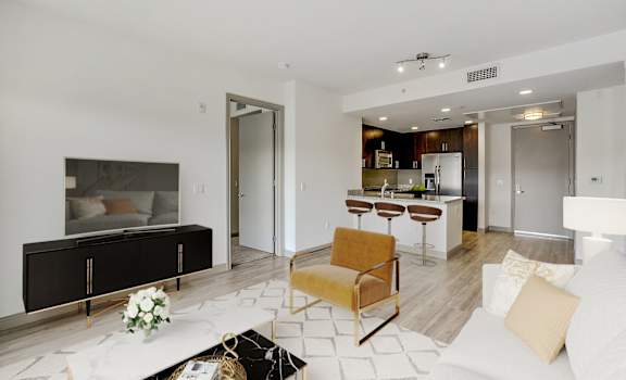a living room with a couch and a kitchen in the background