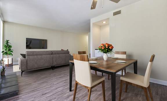 a living room and dining room with a table and chairs