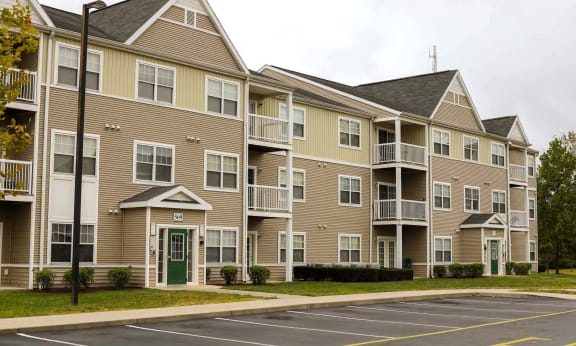 Apartment building with a parking lot in front.