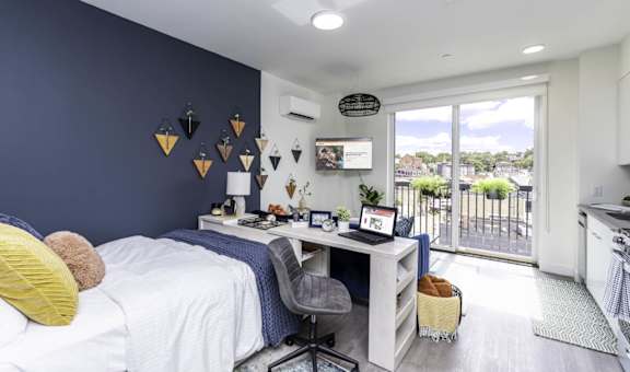 A bedroom with a bed, desk, and chair.