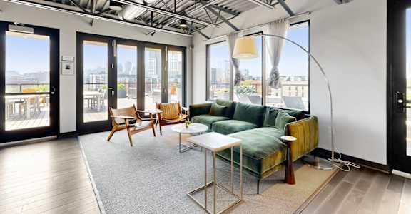 A living room with a couch, chairs, and a table.