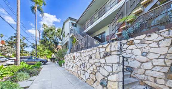 A stone wall runs along the side of a building.