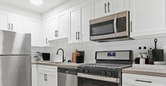 a white kitchen with stainless steel appliances and white cabinets