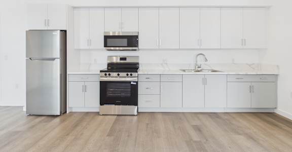 A modern kitchen with a stainless steel refrigerator and a stainless steel oven.