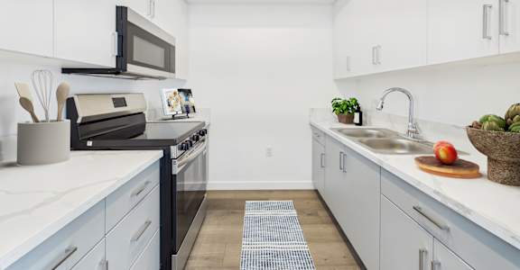 A kitchen with white cabinets and a black stove top oven.
