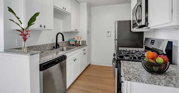 a kitchen with white cabinetry and granite countertops