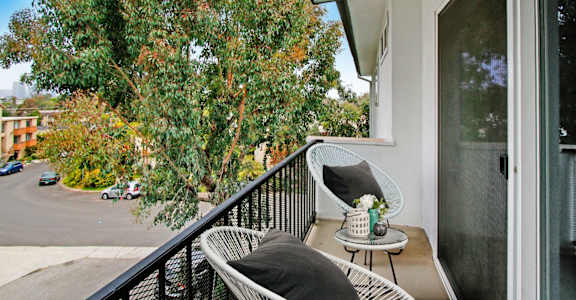 a balcony with two chairs and a table