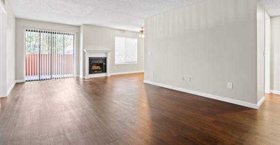 the spacious living room with wood flooring and a fireplace