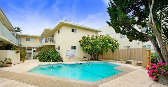 a swimming pool in front of a house with a pool