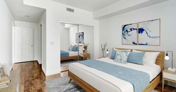 a bedroom with a large bed and a mirror