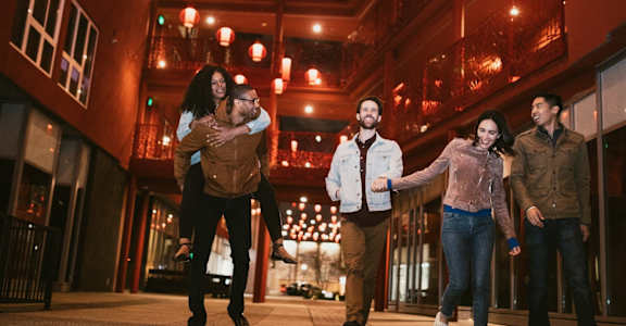a group of people walking down a city street at night
