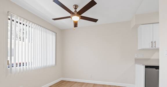 a bedroom with hardwood floors and a ceiling fan