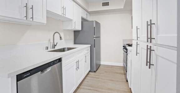 a kitchen with white cabinets and stainless steel appliances
