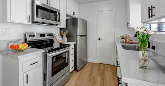 a kitchen with white cabinetry and stainless steel appliances