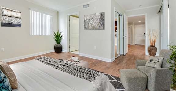a bedroom with a bed and a living room with a couch and a chair